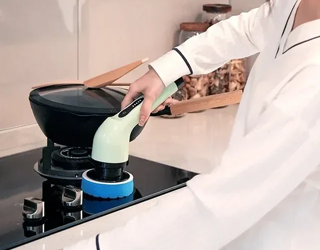 Brosse électrique utilisée sur une plaque de cuisson
